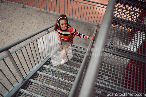 Image of Explore, city and woman on stairs with headphones listening to music, travel and weekend lifestyle. Fashion, beauty and young girl taking walk, adventure and freedom exploring urban town