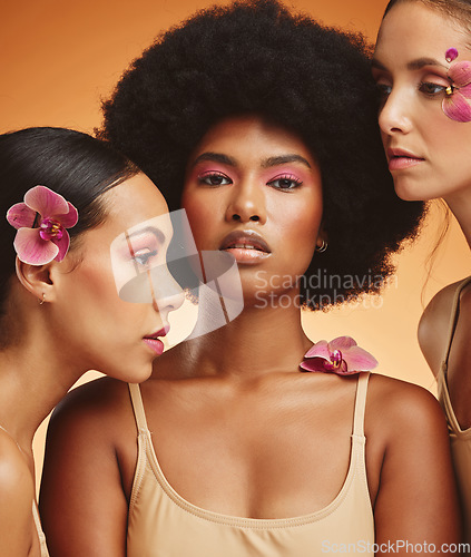 Image of Flowers, beauty and portrait of women with makeup standing in a studio with an orange background. Skincare, diversity and face of beautiful girl model with natural floral, cosmetics and wellness.