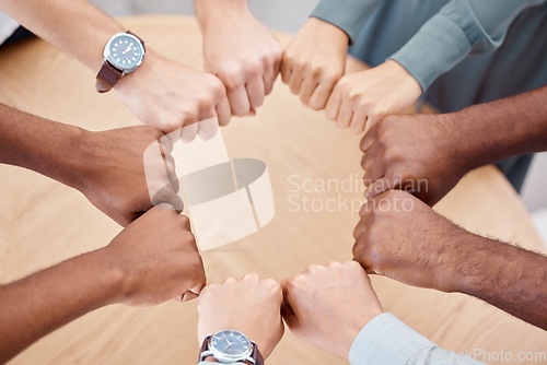 Image of Circle, fist and diversity for solidarity, above and teamwork in office for power, unity and collaboration at table. Group, job and hands in workforce, team and staff for goal, motivation or mission