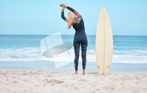 Image of Surfing, stretching and woman surfer on beach standing by surfboard. Blue sky, ocean and girl ready to surf, doing stretch and water sports in Australia. Summer, wellness and fun activity in nature