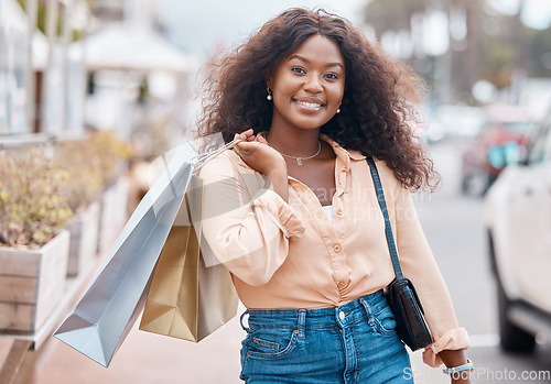 Image of Black woman, shopping and bags with smile in the city for sale, discount and urban outdoors. Portrait of happy African American female shopper holding gifts smiling in happiness for town market
