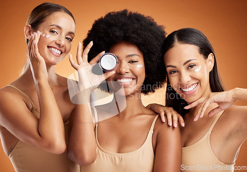 Image of Beauty, skincare and portrait of women with smile in studio with face cream or moisturizer. Happiness, diversity and friends with facial routine for cosmetics, health and wellness by brown background