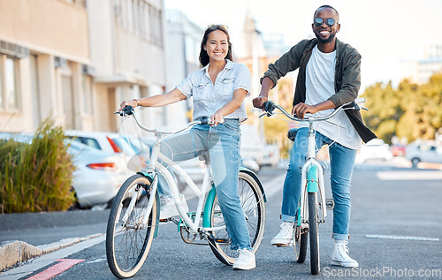 Image of Bike, couple and travel with a black man and asian woman cycling in the city for sightseeing or adventure. Bicycle, carbon footprint and love with a male and female dating in an urban town together