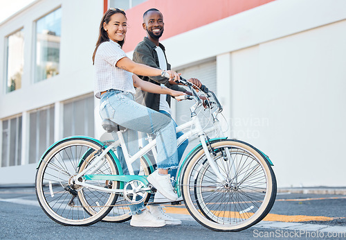 Image of Happy couple, bicycle and city street travel for exercise, fun or adventure outdoor. Black and asian tourist man and woman cycling for carbon footprint on bike in urban town traveling in South Africa