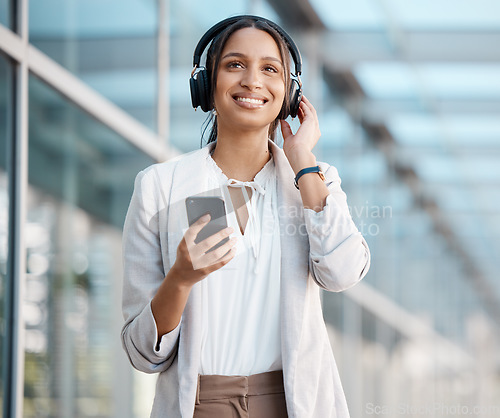 Image of Woman, smartphone and headphones listening to music, radio or podcast on break in cityscape. Young professional, business person and streaming online service, audiobook and subscription playlist.