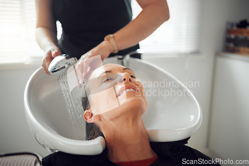 Image of Beauty salon, woman customer and washing hair, service cleaning and scalp treatment at water basin. Professional hairdresser, hair care stylist and cosmetics wellness boutique rinse happy client head