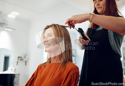 Image of Salon, haircut and style with a woman customer straightening her hair for beauty or wellness. Fashion, client and hair with a female hairdresser or beautician at work with a consumer for haircare