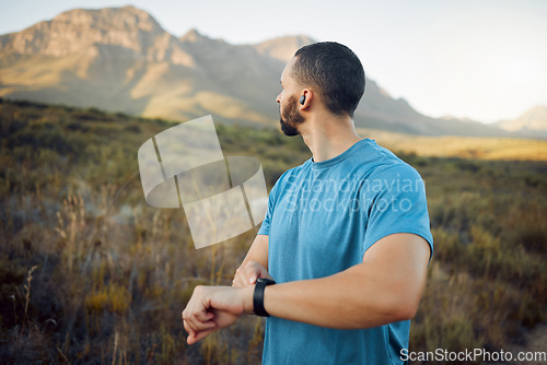 Image of Fitness, man and runner with view of mountain in nature for healthy exercise or workout in the outdoors. Active athletic male training in sports run checking time on watch in the countryside