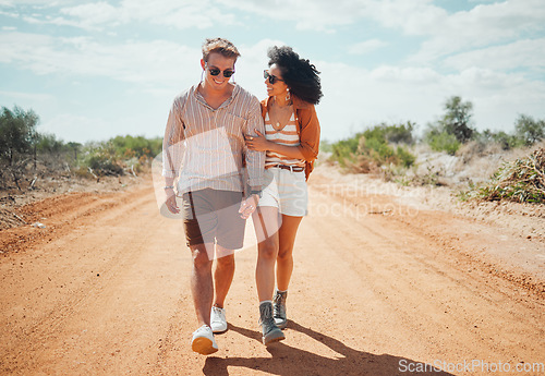 Image of Couple, sunglasses and walking on dirt road in nature on holiday, vacation or summer safari trip. Diversity, love and man, woman and travel outdoors, talking and bonding or spending time together.