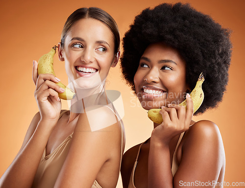 Image of Beauty, diversity and women on banana phone, black woman and friend act, smile and fun pretending to be on phone call. Playful, friendship and studio portrait of happy girls with fruit and fake chat.