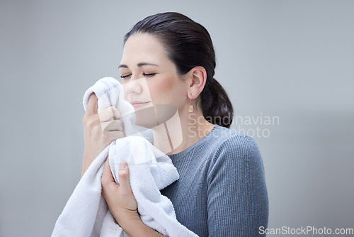 Image of Laundry, woman smelling clean towel and the scent of fresh clothes from washing basket or machine. Housekeeping, cleaning and mom or housekeeper with the nice smell of fabric detergent in happy home