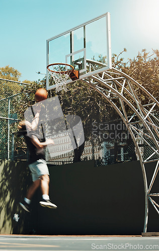 Image of Jumping man, basketball court and scoring goals in fitness workout, training or exercise for health, wellness or professional competition. Sports, energy and player in slam dunk winner game and match