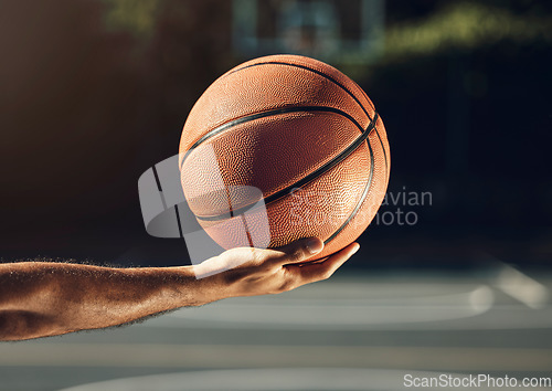 Image of Sport, hand and basketball training at basketball court with man holding ball before practice. Fitness, health and sports guy getting ready for cardio, endurance and energy exercise alone outdoors