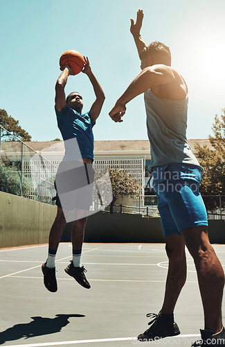 Image of Basketball, sports game and man shooting for goal, fitness exercise and training workout on outdoor basketball court. Street competition, winner mindset and healthy athlete jump and playing match