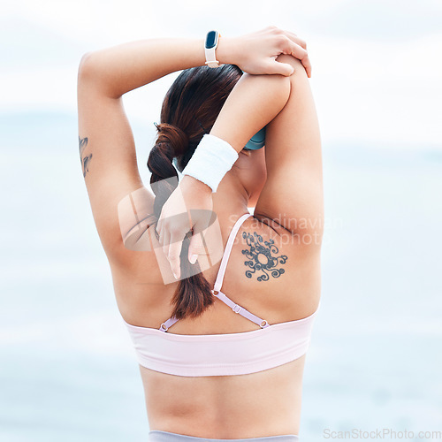 Image of Arms, stretching or fitness woman and music headphones by ocean, sea or water in Canada after workout, training or exercise. Back view of sports, personal trainer or runner athlete ready for wellness