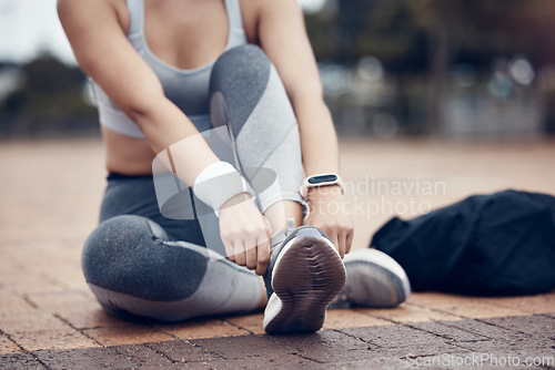 Image of Workout, fitness and woman tying shoes on feet, sitting on ground before marathon training or running. Health, wellness and sports footwear, motivation for exercise for girl athlete or track runner.