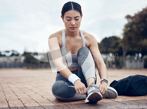 Image of Fitness, sports and woman with shoes ready to start running outdoors for exercise, raining and cardio workout. Young, tying and healthy girl runner with preparing footwear laces for marathon training