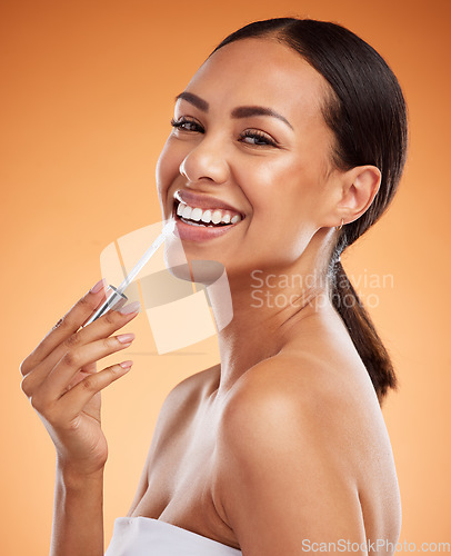 Image of Beauty, skincare and cosmetics with a model black woman using lipstick or lip balm on her mouth in studio on an orange background. Makeup, face and lips with a young female applying a treatment