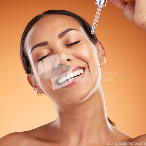 Image of Face, skincare and beauty with a black woman using serum for antiaging on her skin in studio on an orange background. Health, wellness and cosmetics with a female applying a retinol treatment