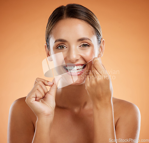 Image of Woman, dental flossing and teeth with smile for clean hygiene and health against a studio background. Portrait of a happy toothy woman smiling in beauty floss for hygienic mouth, oral and gum care