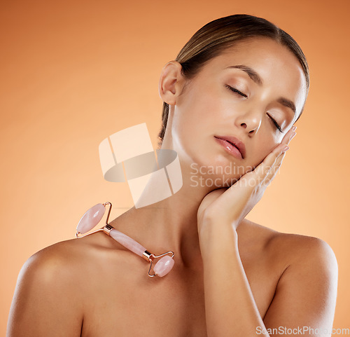 Image of Skincare, beauty and face roller massage with woman in studio background for grooming, hygiene and wellness. Facial, dermatology and wrinkle prevention with model enjoying stone roller tool