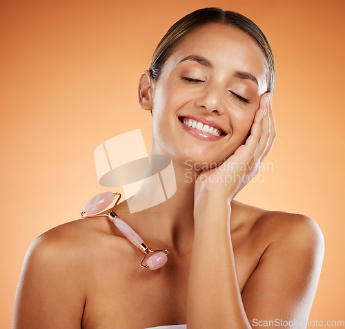 Image of Happy woman in studio, skincare stone roller tool for facial massage and luxury cosmetic product. Pink rose quartz gua sha, smooth soft face and young natural beauty in wellness treatment in studio