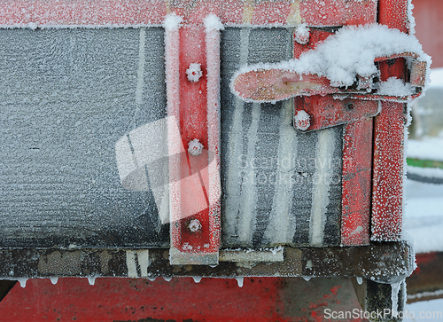 Image of Frozen red colored handle on tractor trailer with ice crystals