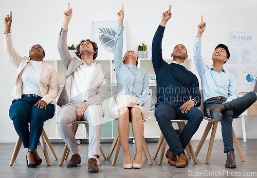 Image of Business people, team and hands raised for asking question during workshop, training or meeting. Collaboration, teamwork and goal with crowd pointing up to volunteer, praise or show advertising idea