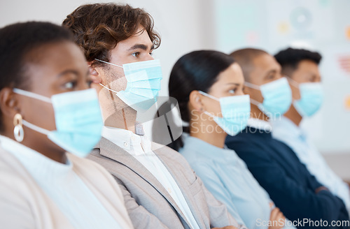Image of Covid, men and women with mask at seminar, tradeshow or presentation sitting in a row. Audience at trade show, conference or business meeting with face mask, focus and attention to health and safety.