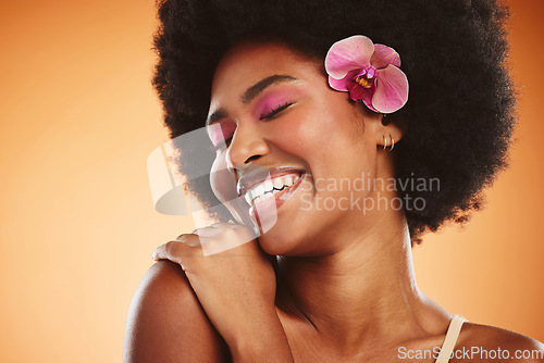 Image of Beauty, smile and cosmetic makeup skincare of a black woman with an orchid looking happy. Natural hair, calm and cosmetics of a person from Jamaica feeling beautiful, relax and happiness in her skin