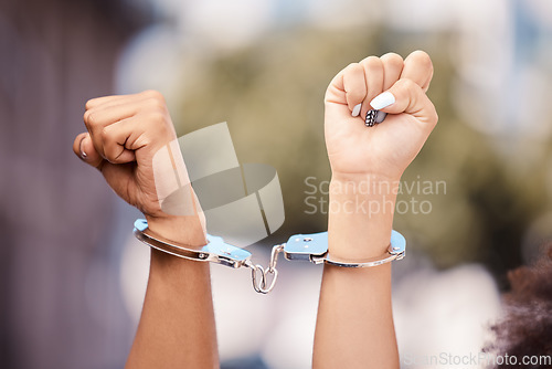 Image of Activist woman hands fist, handcuffs and social justice protest of women protesting outdoor. Hand view of empowerment, black lives matter or iran sexual assault fight for human rights with power