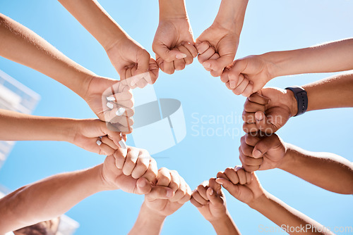 Image of Fist hands, circle and community support diversity people, protest group and freedom fight on blue sky background. Below solidarity, teamwork and motivation for justice goal, trust and society power