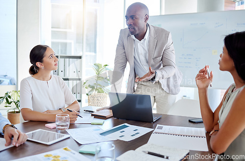 Image of Business, black man and speaker, presentation leader and planning with business people in meeting. Diversity, laptop and paperwork, talking and listening to corporate pitch and project strategy.