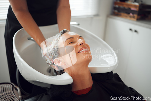 Image of Hair, smile and wash, woman in salon relax with head back and hairdresser cleaning with shampoo and conditioner. Beauty, hair care and a luxury massage for client with professional stylist in spa.