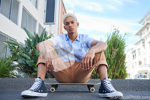 Image of Skateboard, gen z and cool skater man in the city with a serious look outdoor. Portrait of a urban person from Mexico relax after skate training, fitness and cardio workout practice on the road