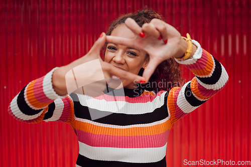 Image of Happy, black woman and finger frame over eyes for funny face expression on red background. Fashion, comic and positive perspective with female from South Africa with hand gesture feeling playful