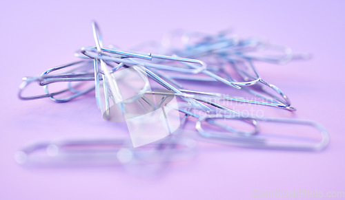 Image of Paper clips together in pile, connected and a chain on purple background. Office supplies, organization and project management with paperclip for business strategy and planning to organize paperwork.