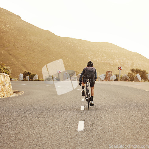 Image of Fitness, cycling and sports man on a bicycle at sunset with mountain view in South Africa, exercise, freedom and health. .Road, cyclist and marathon training by athletic male on morning cardio ride