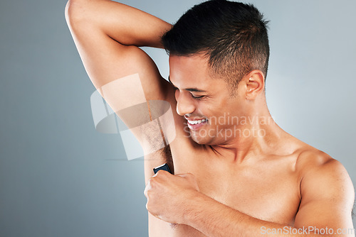 Image of Man, electric shaving and armpit hair removal for skincare, clean body health and aesthetic wellness cosmetics on grey studio background. Happy guy grooming underarm, razor trimmer and fresh hygiene