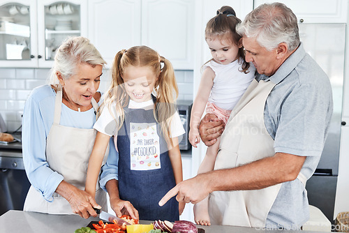 Image of Cooking, smile and grandparents teaching children to cook food together in the kitchen of their house. Happy and young kids learning and helping an elderly man and woman with healthy lunch or dinner