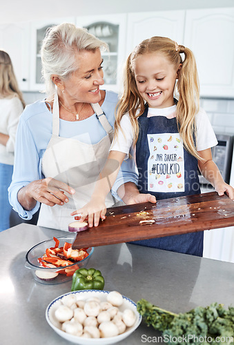 Image of Children, family and cooking with a girl and grandmother preparing a meal in the kitchen of their home together. Food, love and learning with a senior woman teaching her granddaughter about cooking