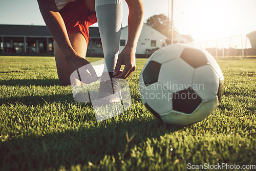Image of Fitness, shoes and soccer player ready for sports training, exercise and cardio workout on football field outdoors. Hands, footwear and athlete tying boots to start a practice game or match