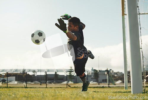 Image of Soccer, goalkeeper and jump, saving ball from goals at outdoor sports field. Football, goalie and competition game with fitness, goal keeper and soccer ball on grass, success and mission to save goal