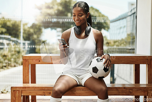 Image of Soccer, phone and black woman football athlete with a ball on sports rest after exercise and fitness. Training workout and game break of a healthy person smile using mobile technology and 5g internet