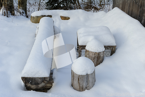 Image of A Snow Covered Bench and Table