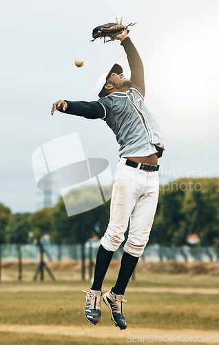 Image of Baseball, sport and person fielder jump on an outdoor sports field during sport game or match. Fitness, training motivation and cardio workout of an athlete man with focus ready to catch a fast ball