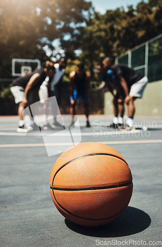 Image of Basketball, ball and outdoor court with athlete group or team talk strategy during break at game for motivation and teamwork for streetball. Male players in the USA playing for fitness and exercise