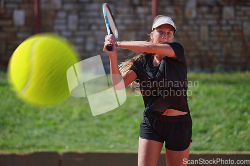 Image of A professional female tennis player serves the tennis ball on the court with precision and power