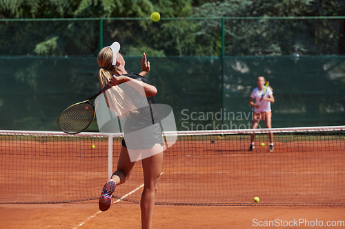 Image of Young girls in a lively tennis match on a sunny day, demonstrating their skills and enthusiasm on a modern tennis court.