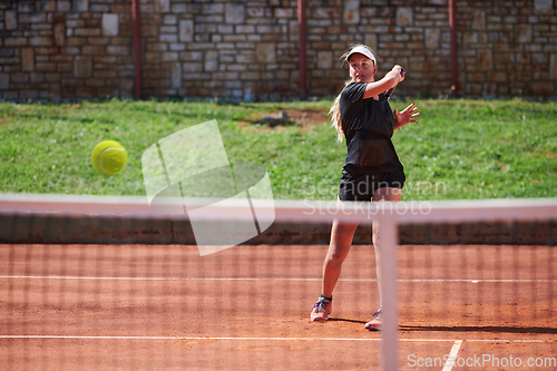 Image of A young girl showing professional tennis skills in a competitive match on a sunny day, surrounded by the modern aesthetics of a tennis court.